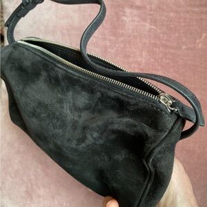 The Row “90’s bag” in black nubuck. See on The Row website.